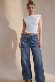 Pantalón de denim, fit wide leg, tiro alto, pretina criss cross con trabillas, bolsillos delanteros y traseros de parche. Cierre frontal con botón y cremallera oculta.