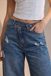 Pantalón de denim, fit wide leg, tiro alto, pretina criss cross con trabillas, bolsillos delanteros y traseros de parche. Cierre frontal con botón y cremallera oculta.