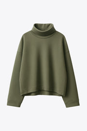 Jersey de fit fluido, cuello alto con doblez, manga larga con hombro caído y rib en puño.