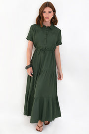 Maxi vestido camisero de manga corta con doblez en borde, cuello camisero, plisados frontales, capas de olanes en bajo, jareta ajustable en cintura y cierre frontal con hilera de botones en contraste.