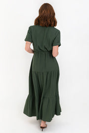 Maxi vestido camisero de manga corta con doblez en borde, cuello camisero, plisados frontales, capas de olanes en bajo, jareta ajustable en cintura y cierre frontal con hilera de botones en contraste.