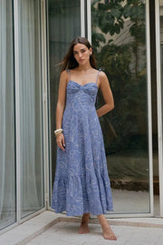 Maxi vestido de corte en a, estampado floral, tirantes delgados con nudo amarrable, escote corazón con cortes y detalles plisados. Cierre posterior con cremallera visible en contraste y olanes en borde de bajo.