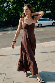Maxi vestido de corte en a, tirantes delgados con nudo amarrable, escote corazón con cortes y detalles plisados. Cierre posterior con cremallera visible en contraste y olanes en borde de bajo.
