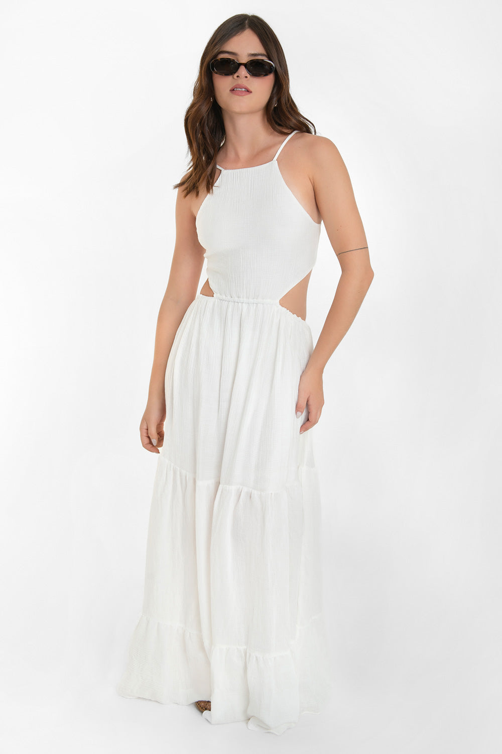 Maxi vestido de cuello halter con tirantes delgados ajustables, corte en a, bajo con capas de olanes, cut out en costados y espalda. Detalle de rib elástico en cintura y cierre posterior con lazo amarrable.