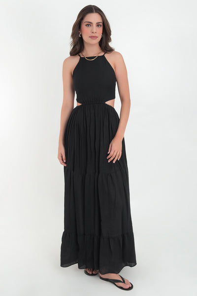 Maxi vestido de cuello halter con tirantes delgados ajustables, corte en a, bajo con capas de olanes, cut out en costados y espalda. Detalle de rib elástico en cintura y cierre posterior con lazo amarrable.
