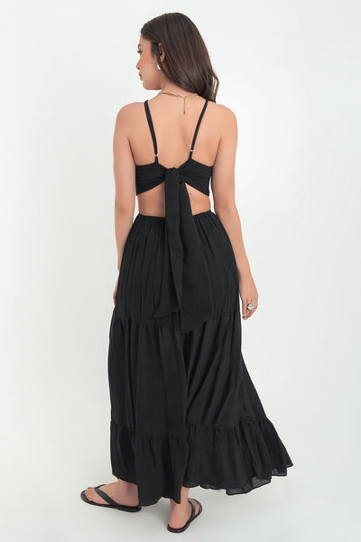 Maxi vestido de cuello halter con tirantes delgados ajustables, corte en a, bajo con capas de olanes, cut out en costados y espalda. Detalle de rib elástico en cintura y cierre posterior con lazo amarrable.