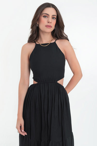 Maxi vestido de cuello halter con tirantes delgados ajustables, corte en a, bajo con capas de olanes, cut out en costados y espalda. Detalle de rib elástico en cintura y cierre posterior con lazo amarrable.