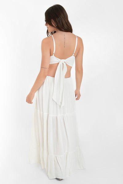 Maxi vestido de cuello halter con tirantes delgados ajustables, corte en a, bajo con capas de olanes, cut out en costados y espalda. Detalle de rib elástico en cintura y cierre posterior con lazo amarrable.
