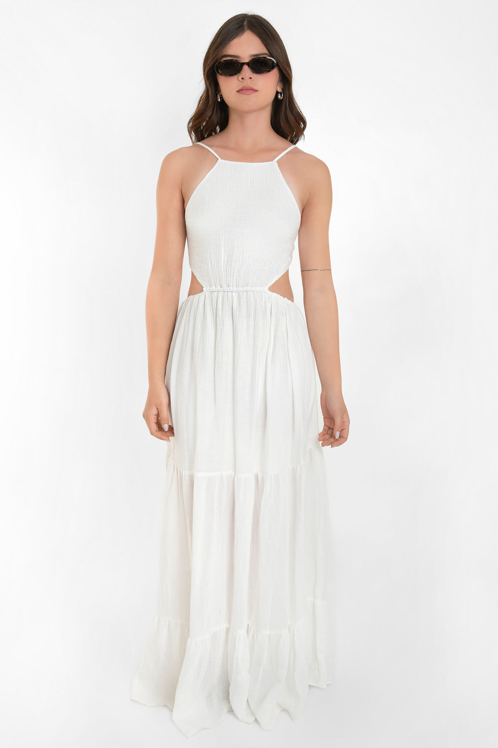 Maxi vestido de cuello halter con tirantes delgados ajustables, corte en a, bajo con capas de olanes, cut out en costados y espalda. Detalle de rib elástico en cintura y cierre posterior con lazo amarrable.