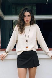 Falda pantalón mini, de fit ajustado, cintura alta, corte frontal con abertura y cierre lateral con cremallera oculta.