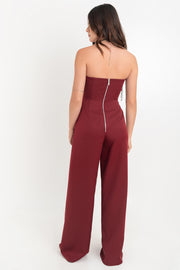 Palazzo ajustado strapless de fit wide leg, escote v con cut out en costados, detalle de cruce con aberturas frontales y cierre posterior con cremallera visible en contraste.