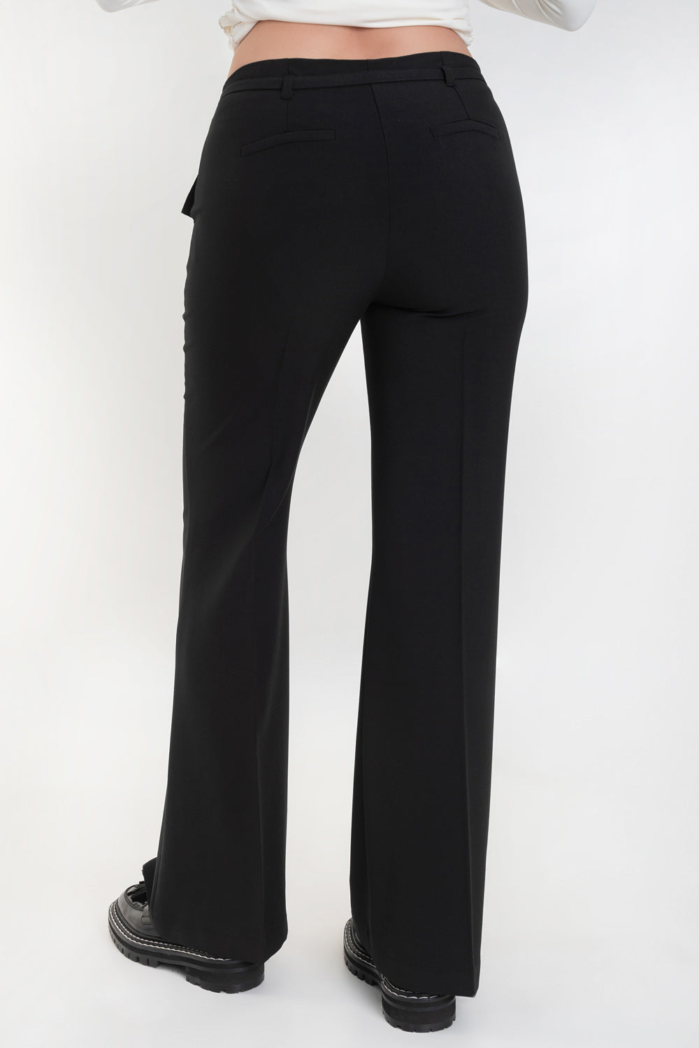Pantalón ajustado de fit flare, cintura media con pretina, trabillas y cinturón delgado con hebilla, raya frontal y posterior. Vivos decorativos posteriores, cierre frontal con broche y cremallera oculta.