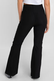 Pantalón ajustado de fit flare, cintura alta con pretina y trabillas, bolsillos delanteros y vivos decorativos posteriores. Cierre frontal con broche y cremallera ocultos.