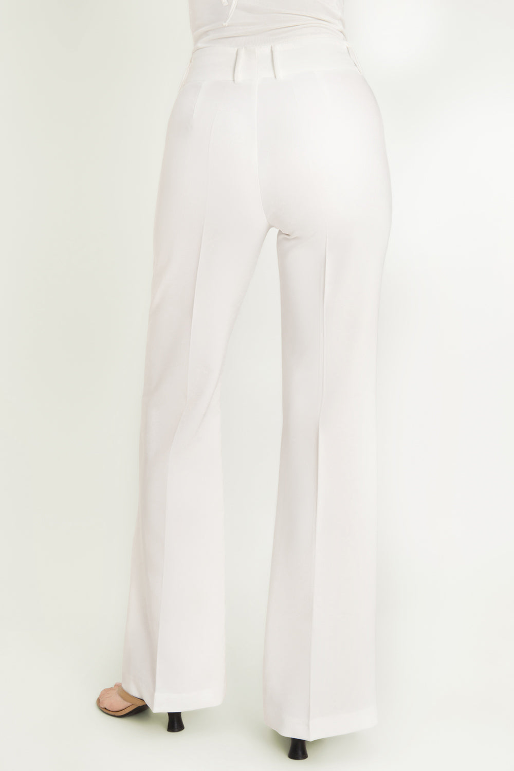 Pantalón ajustado de fit flare, cintura alta con pretina y trabillas, raya frontal y posterior, cierre con cremallera oculta y botones.