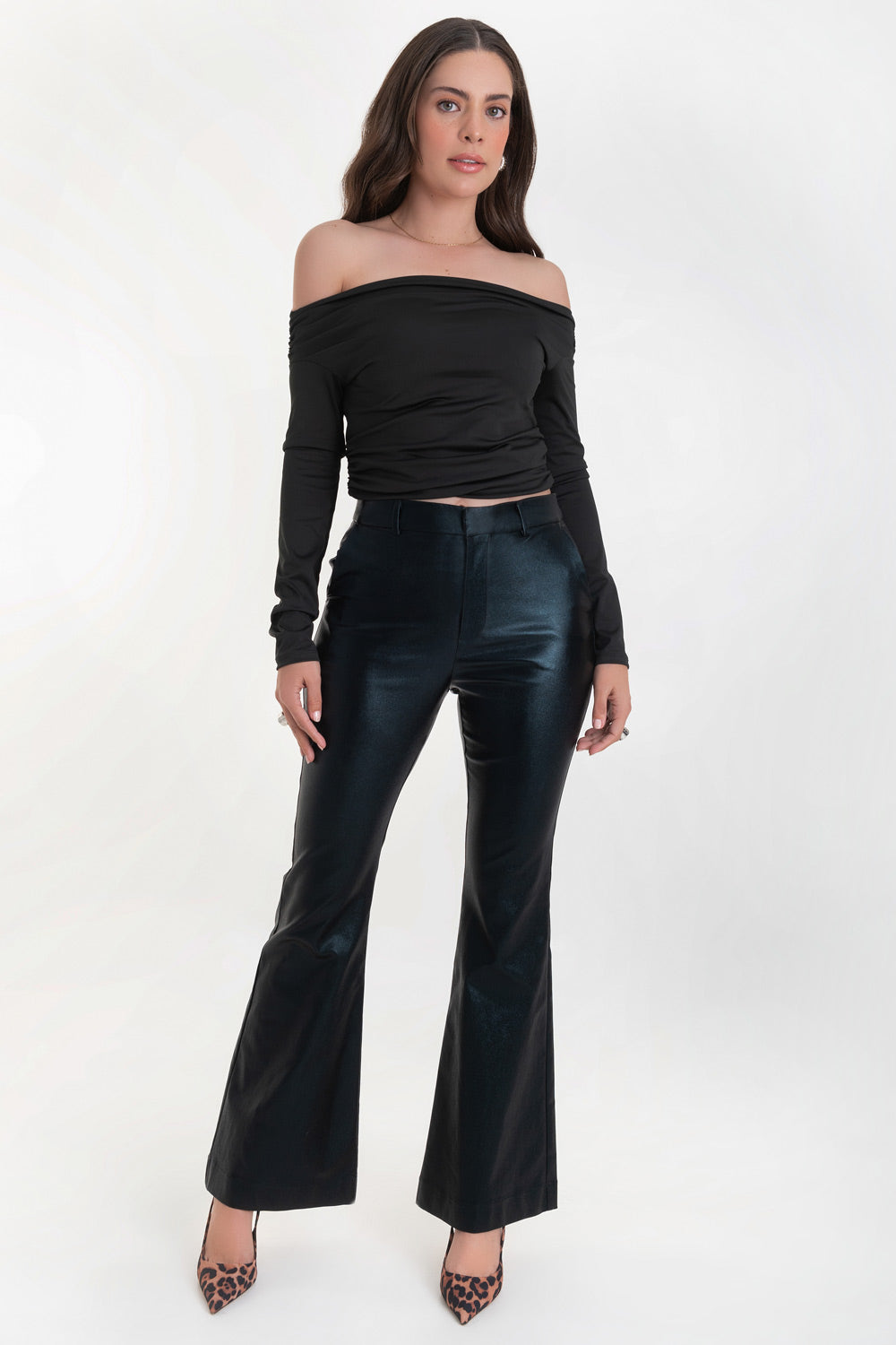 Pantalón ajustado de fit flare, efecto piel, cintura media con pretina y trabillas, bolsillos delanteros y vivos decorativos posteriores. Cierre frontal con broche y cremallera ocultos.