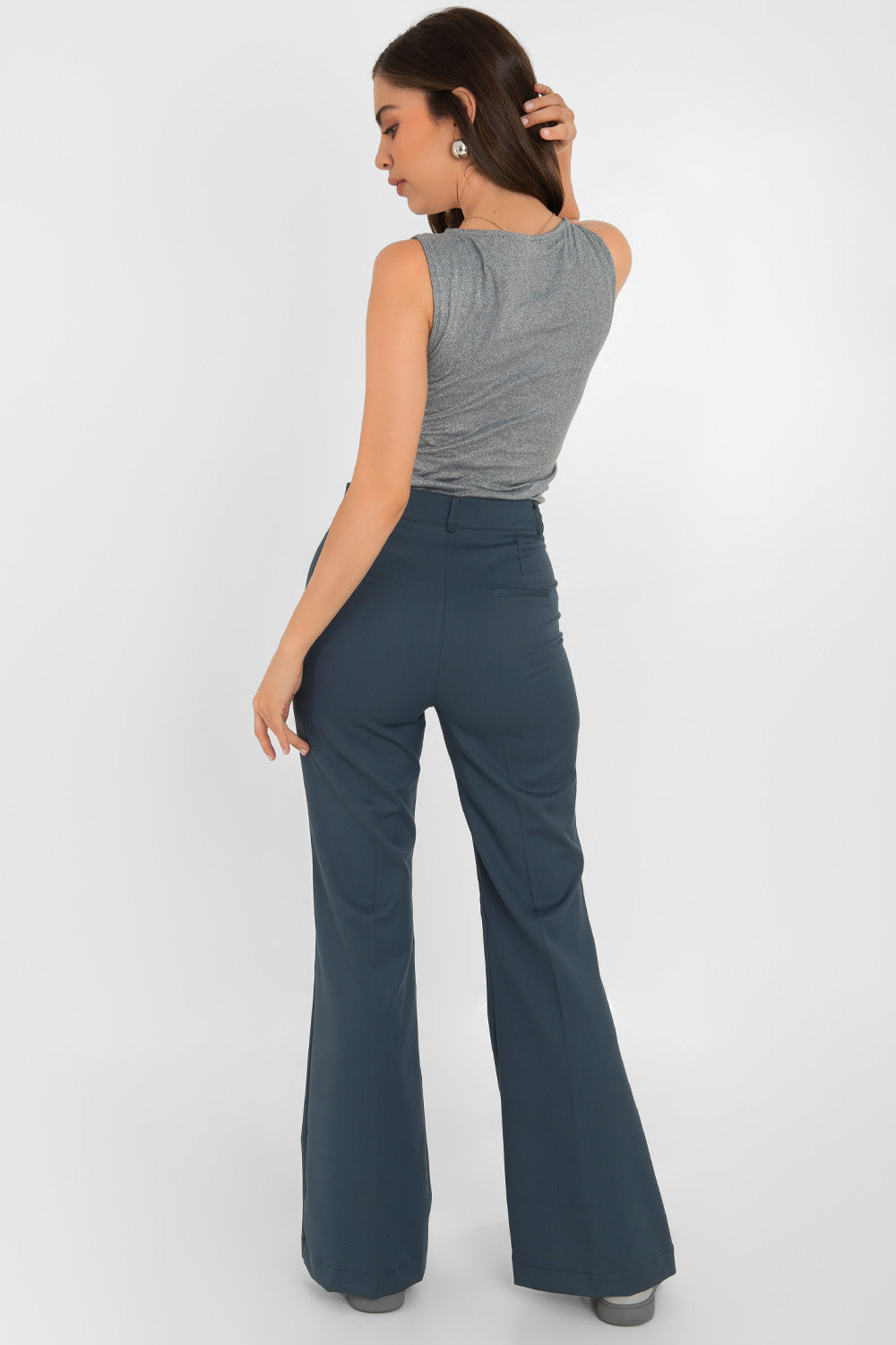 Pantalón ajustado de fit flare, cintura alta con pretina y trabillas, vivo decorativo posterior, cierre frontal con broche y cremallera ocultos.