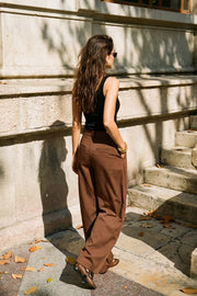 Pantalón de fit wide leg, pinzas frontales, cintura alta con pretina y trabillas, bolsillos delanteros y vivos decorativos traseros. Cierre frontal con broche y cremallera ocultos.