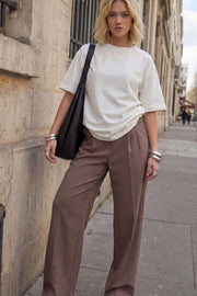 Pantalón fluido de fit wide leg, estampado rayas, cintura alta con pretina elástica posterior, trabillas, pinzas frontales y bolsillos delanteros.