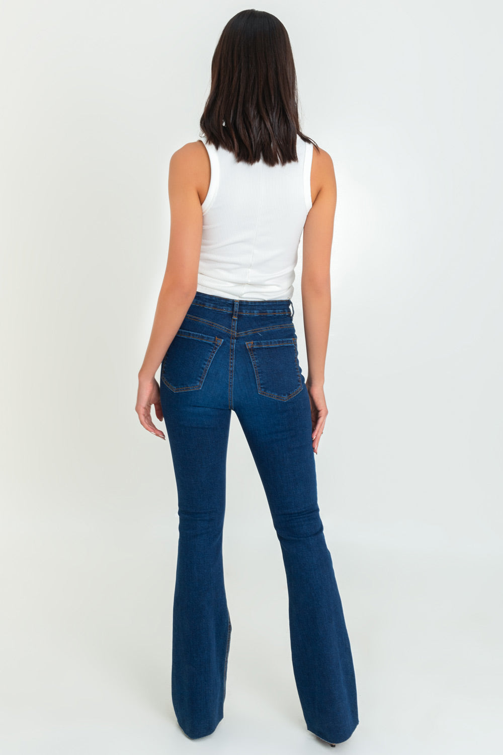 Pantalón boot cut de denim, fit ajustado, cintura alta con pretina y trabillas, bolsillos delanteros y traseros de parche. Cierre frontal con botón y cremallera oculta. Detalle de rotos en bajo.