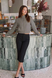 Pantalón capri de fit ajustado, cintura media, vivos decorativos frontales, detalle de raya y abertura lateral en bajo. Cierre frontal con broche y cremallera ocultos.