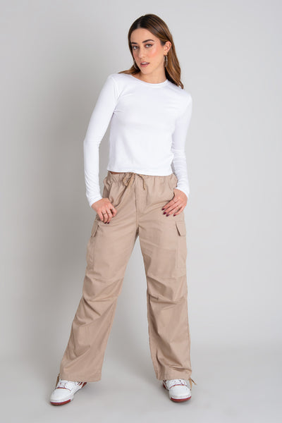 Pantalón cargo de cintura alta elástica con jareta frontal ajustable, fit amplio, plisados decorativos en rodillas, bolsillos delanteros, laterales cargo con cartera y traseros de parche. Detalle de bajo con jaretas ajustables, cierre frontal con botón y cremallera oculta.