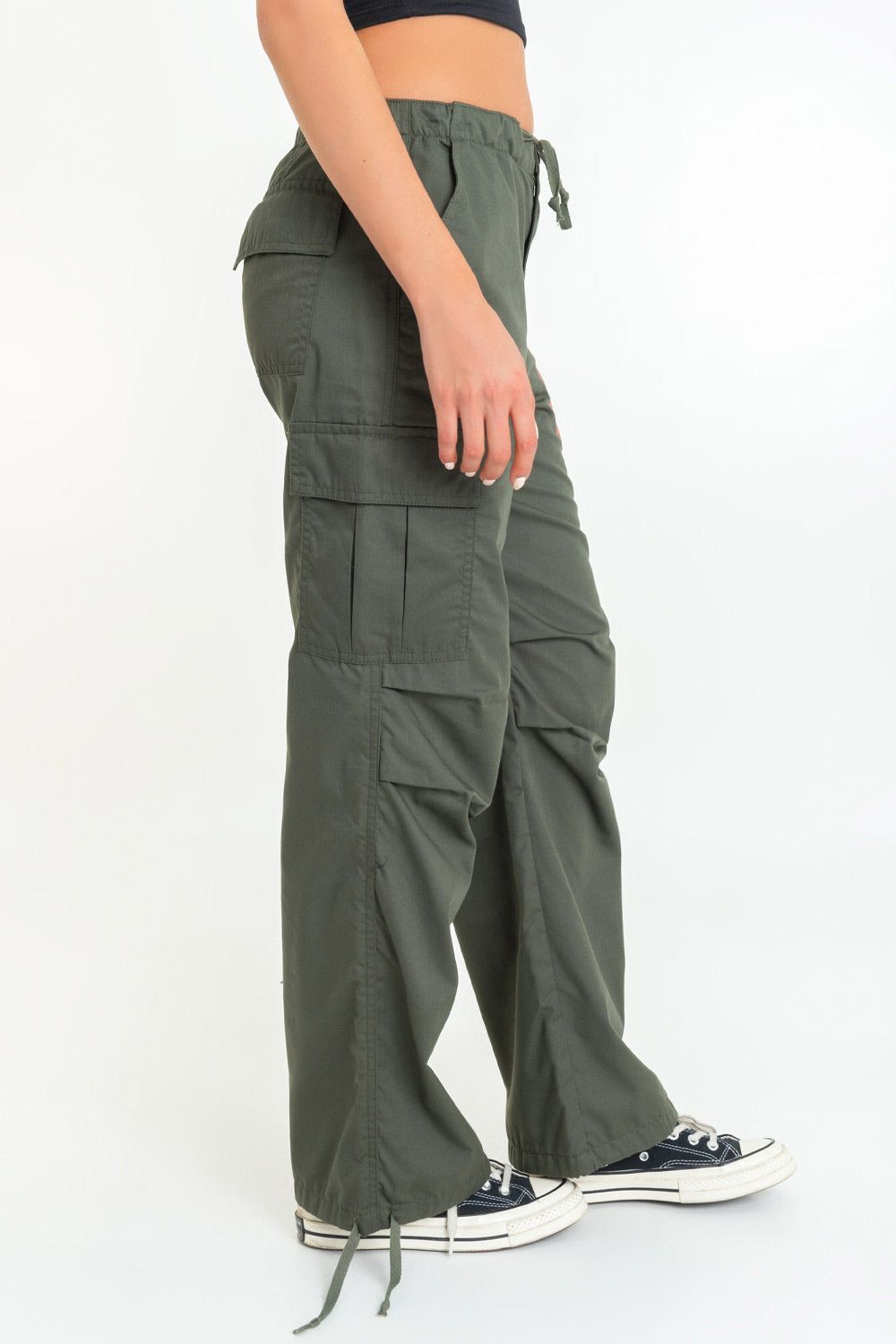 Pantalón cargo de cintura alta elástica con jareta frontal ajustable, fit amplio, plisados decorativos en rodillas, bolsillos delanteros, laterales cargo con cartera y traseros de parche. Detalle de bajo con jaretas ajustables, cierre frontal con botón y cremallera oculta.