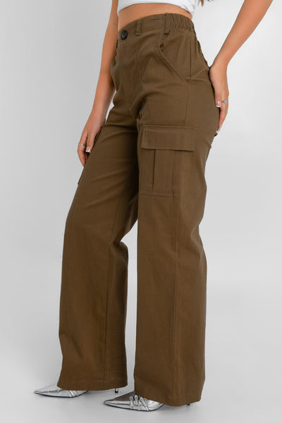 Pantalón cargo de fit wide leg, cintura alta con pretina y trabillas, bolsillos delanteros y laterales cargo con cartera, bolsillos decorativos posteriores con cartera, pretina elástica posterior y cierre frontal con botón y cremallera oculta. Detalle de raya frontal.