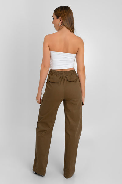 Pantalón cargo de fit wide leg, cintura alta con pretina y trabillas, bolsillos delanteros y laterales cargo con cartera, bolsillos decorativos posteriores con cartera, pretina elástica posterior y cierre frontal con botón y cremallera oculta. Detalle de raya frontal.