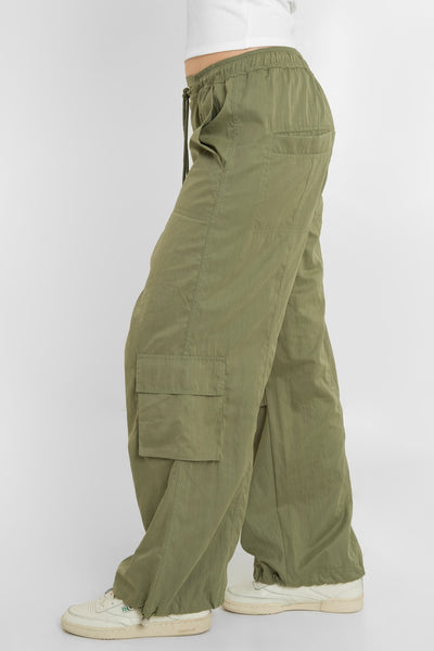 Pantalón cargo parachute de cintura media, pretina elástica con jareta frontal ajustable, fit amplio, bolsillos delanteros, laterales cargo con cartera y traseros con vivos. Detalle costuras decorativas centrales y bajo con jaretas elásticas ajustables.