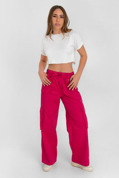 Pantalón cargo de cintura alta con pretina elástica y jareta frontal ajustable, fit wide leg, bolsillos delanteros, laterales y traseros cargo de cartera con botones. Detalle de bolsillos frontales cargo, trabillas y argolla en contraste.