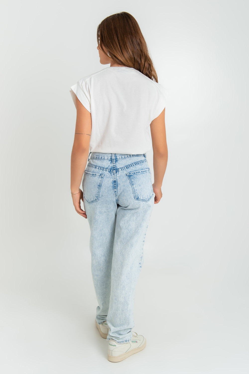 Pantalón de denim de mom fit, cintura alta con pretina, trabillas, bolsillos delanteros y traseros de parche. Cierre frontal con botón y cremallera oculta.