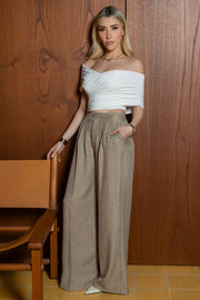 Pantalón fluido de cintura alta con pretina y trabillas, fit wide leg, pinzas frontales, bolsillos delanteros, detalle de raya frontal y posterior. Cierre frontal con botón y cremallera oculta.