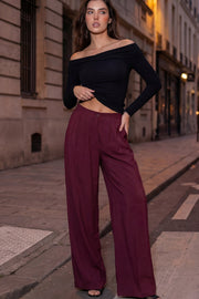 Pantalón fluido de cintura alta con pretina y trabillas, fit wide leg, pinzas frontales, bolsillos delanteros, detalle de raya frontal y posterior. Cierre frontal con botón y cremallera oculta.