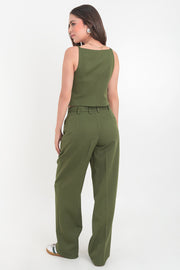 Pantalón de fit wide leg, cintura alta con pretina y trabillas, pinzas frontales, bolsillos delanteros, vivo decorativo posterior, cierre frontal con cremallera oculta y botón forrado. Detalle de raya frontal y posterior. 