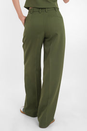 Pantalón de fit wide leg, cintura alta con pretina y trabillas, pinzas frontales, bolsillos delanteros, vivo decorativo posterior, cierre frontal con cremallera oculta y botón forrado. Detalle de raya frontal y posterior. 