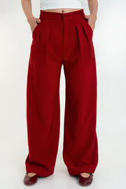 Pantalón de fit wide leg, pinzas frontales, cintura alta con pretina y trabillas, bolsillos delanteros, cierre frontal con broche y cremallera ocultos.