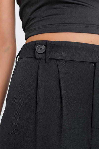 Pantalón de fit culotte, cintura alta con pretina elástica posterior, trabillas, pinzas frontales, bolsillos delanteros y vivos decorativos posteriores. Cierre frontal con trabilla, botón en contraste y cremallera oculta.