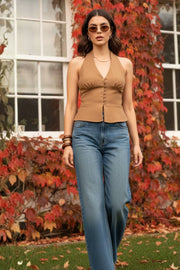 Pantalón de denim, fit recto, cintura alta con pretina y trabillas, detalle de rotos en bajo, bolsillos delanteros y traseros de parche. Cierre frontal con botón y cremallera oculta.