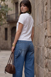 Pantalón de denim, fit baggy, cintura alta con pretina y trabillas, bolsillos delanteros y traseros de parche. Cierre con botón y cremallera oculta. Detalle de bolsillo carpenter y trabillas ajustables en pretina.