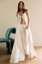 Pantalón de denim fit palazzo, cintura baja con pretina y trabillas, pinzas frontales, bolsillos delanteros, cierre frontal con botón y cremallera oculta.