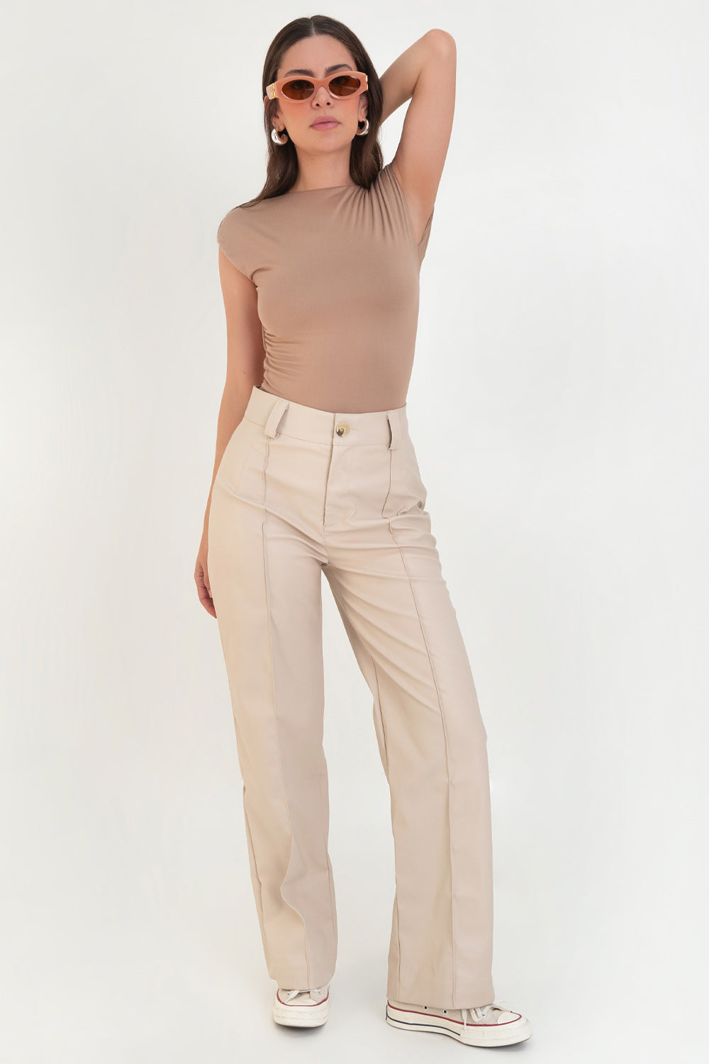 Pantalón de efecto piel, fit wide leg, cintura alta con pretina y trabillas, detalle de raya frontal con costura y cierre frontal con botón en contraste y cremallera oculta.