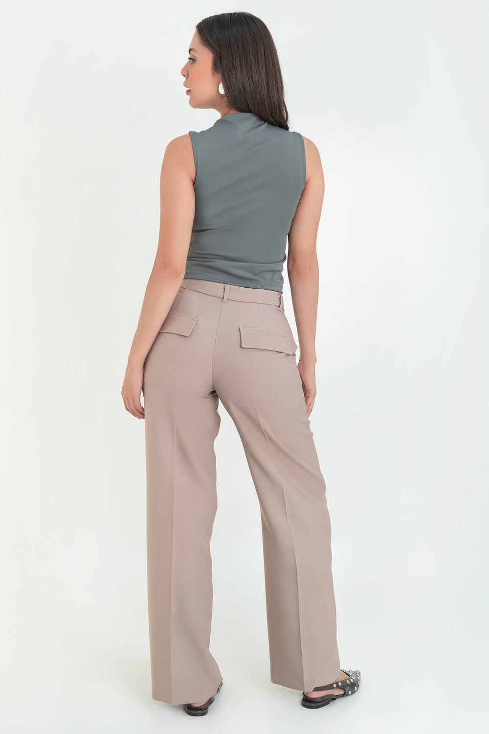Pantalón de fit recto, cintura media con pretina y trabillas, detalle de raya frontal, bolsillos delanteros y posteriores decorativos con cartera. Cierre frontal con broche y cremallera ocultos.