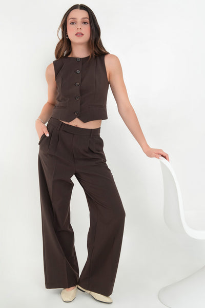 Pantalón de fit recto, pinzas frontales con raya, cintura media con pretina elástica posterior y trabillas, bolsillos delanteros y vivo decorativo posterior. Cierre frontal con broche y cremallera ocultos.