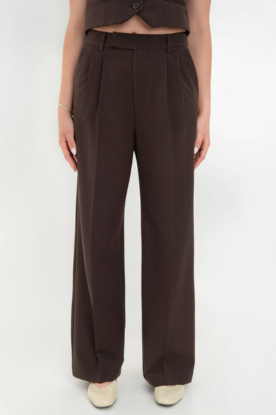 Pantalón de fit recto, pinzas frontales con raya, cintura media con pretina elástica posterior y trabillas, bolsillos delanteros y vivo decorativo posterior. Cierre frontal con broche y cremallera ocultos.