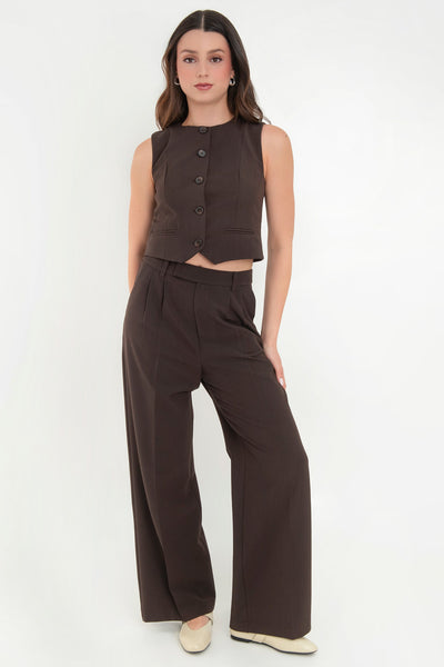 Pantalón de fit recto, pinzas frontales con raya, cintura media con pretina elástica posterior y trabillas, bolsillos delanteros y vivo decorativo posterior. Cierre frontal con broche y cremallera ocultos.