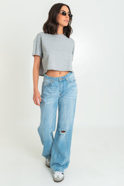 Pantalón de denim, fit wide leg, cintura media con pretina y trabillas, bolsillos delanteros, traseros de parche, detalle de rotos en rodilla y bajo. Cierre frontal con botón y cremallera oculta.