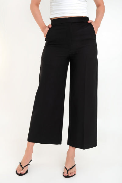 Pantalón de fit wide leg, cintura alta con pretina, bolsillos delanteros y vivos decorativos posteriores, detalle de raya frontal y posterior. Cierre frontal con broche y cremallera oculta.