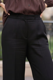 Pantalón de fit wide leg, cintura alta con pretina, bolsillos delanteros y vivos decorativos posteriores, detalle de raya frontal y posterior. Cierre frontal con broche y cremallera oculta.