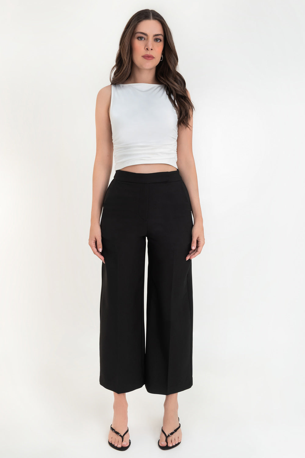 Pantalón de fit wide leg, cintura alta con pretina, bolsillos delanteros y vivos decorativos posteriores, detalle de raya frontal y posterior. Cierre frontal con broche y cremallera oculta.
