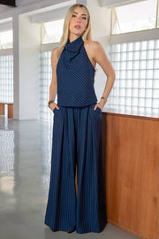 Pantalón de lino, estampado rayas, fit palazzo, cintura alta con pretina elástica posterior, trabillas, bolsillos delanteros y pinzas frontales. Cierre frontal con botón y cremallera oculta.
